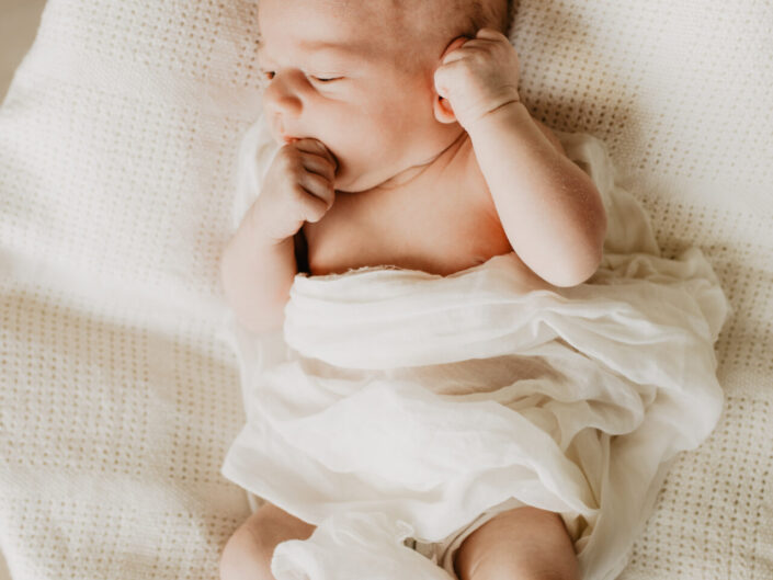 Ein Neugeborenes was in einem Korb fotografiert wird