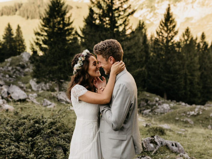 Ein Brautpaar, was sich in den Bergen küsst